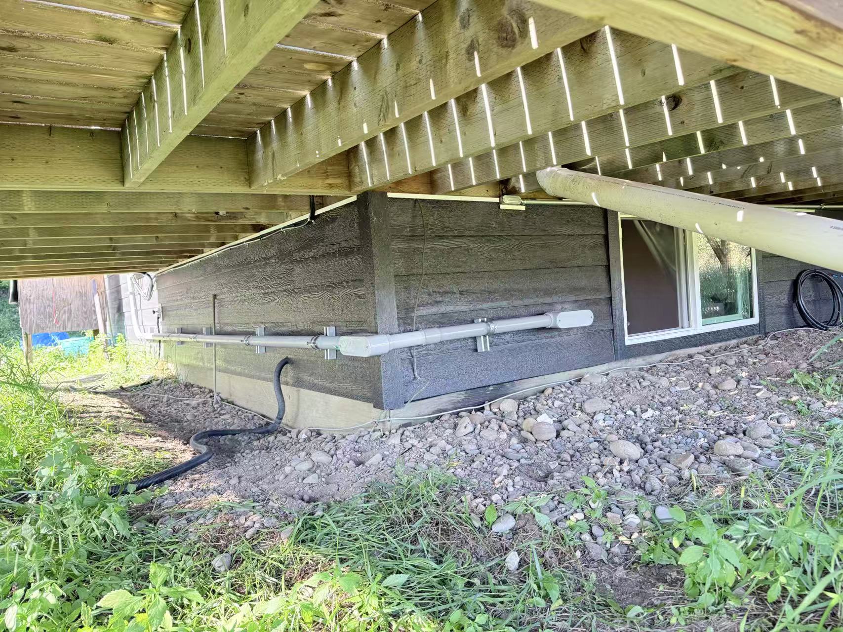 Electrical conduit routed beneath a residential deck