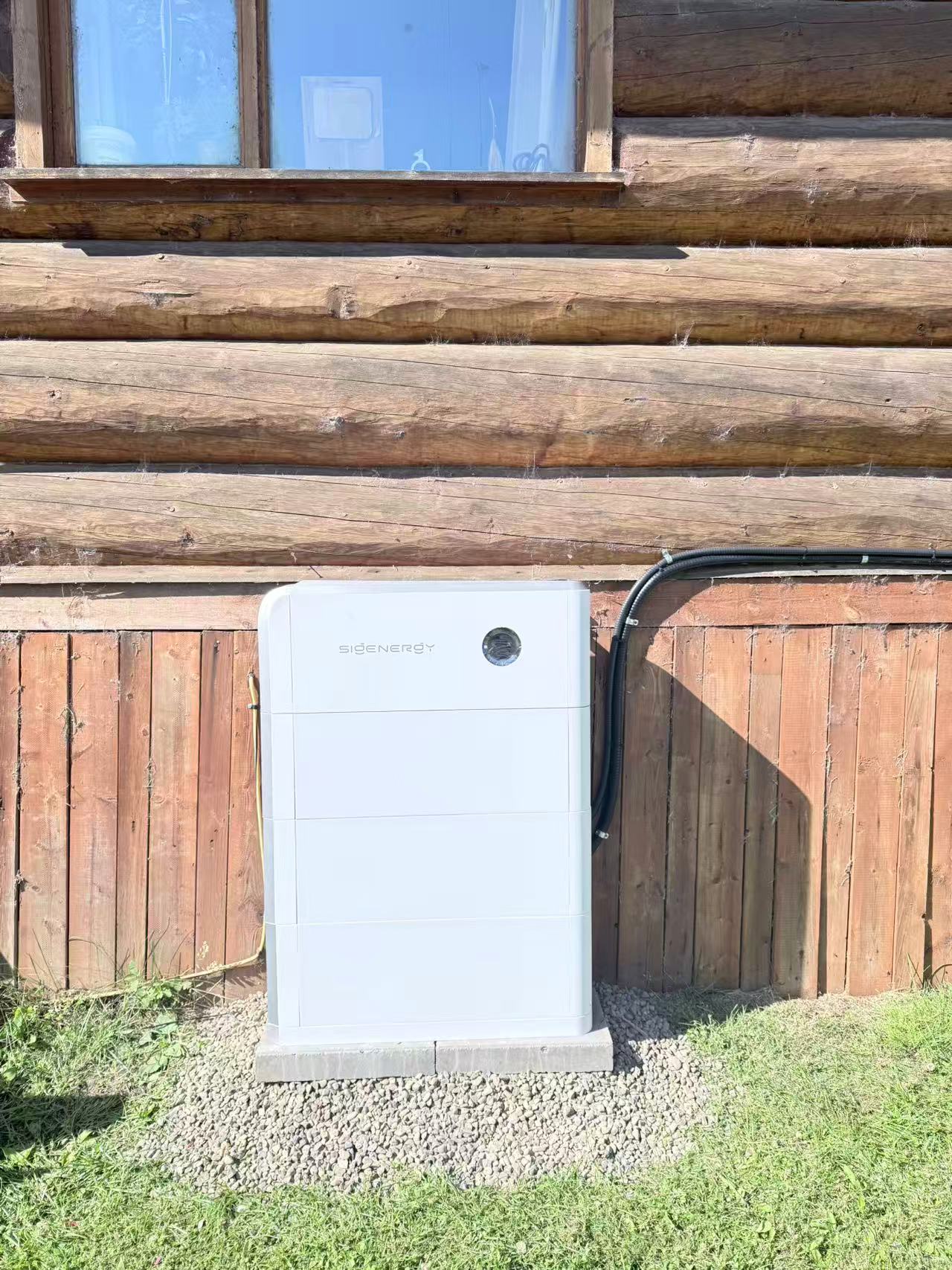 Close view of a white Sigenergy battery cabinet and conduit