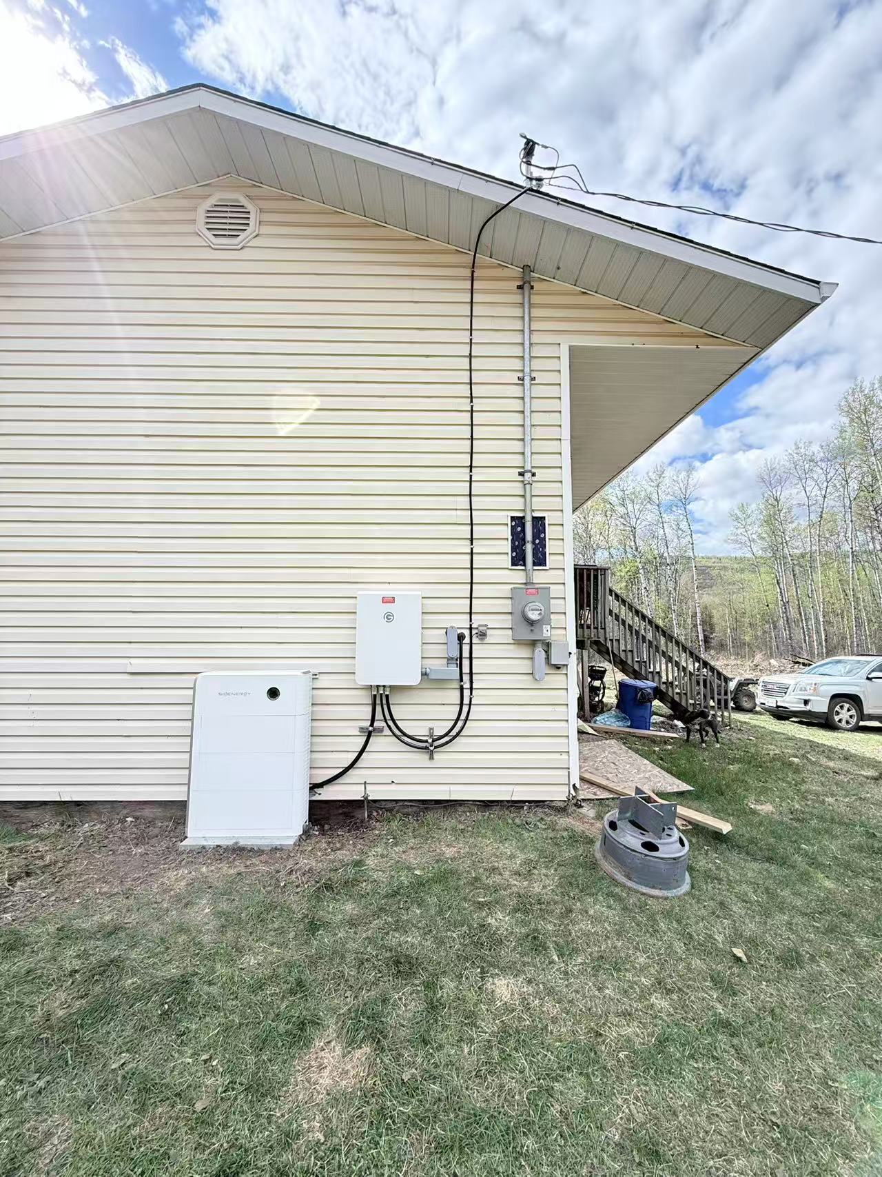 White Sigenergy storage equipment installed outside a house beside a parked SUV